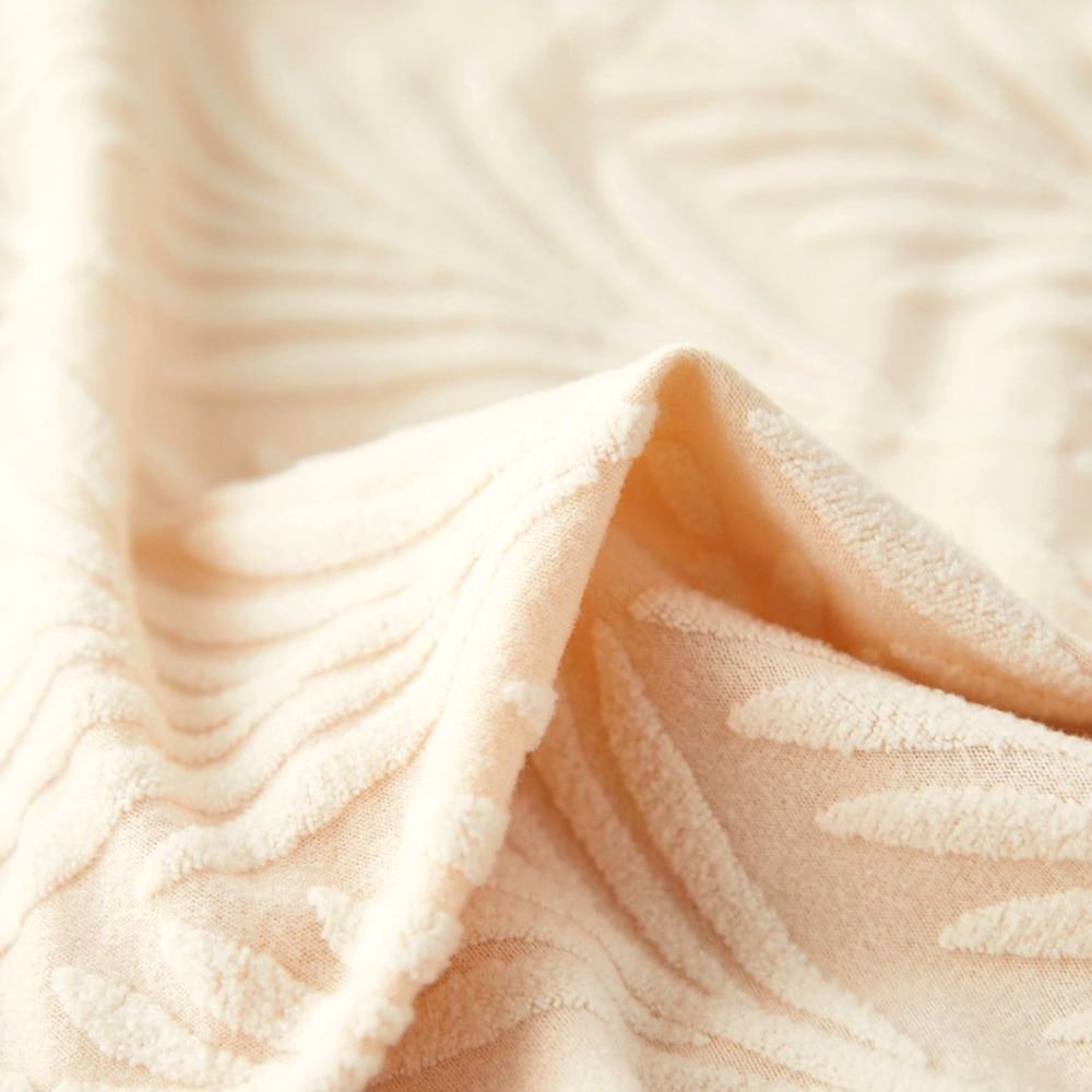 Vista en primer plano de la tela de la funda elástica jacquard Velvet Haven en blanco suave, mostrando su patrón texturizado de tejido de palma y la calidad del material.