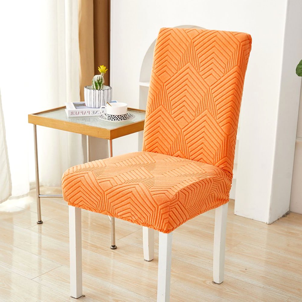 Funda de silla elástica jacquard Velvet Haven en naranja atardecer con patrón Chevron Maze, mostrando su ajuste elástico en una silla de comedor. Perfecta para añadir un toque vibrante a la decoración del hogar.