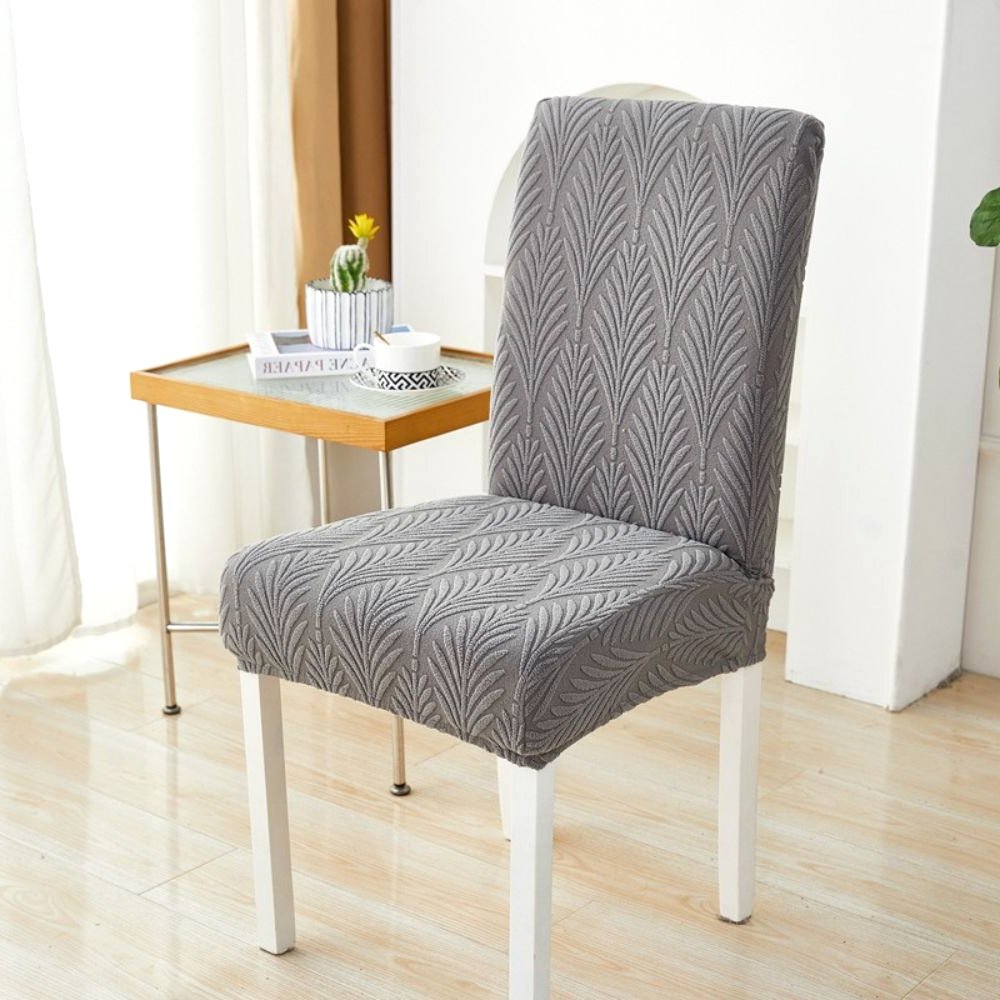 Anthrazitgrauer Palmenwebelastischer Jacquard-Stuhlbezug auf einem Esszimmerstuhl, der seine dehnbare Passform und elegantes Design in einem Wohnambiente zeigt.