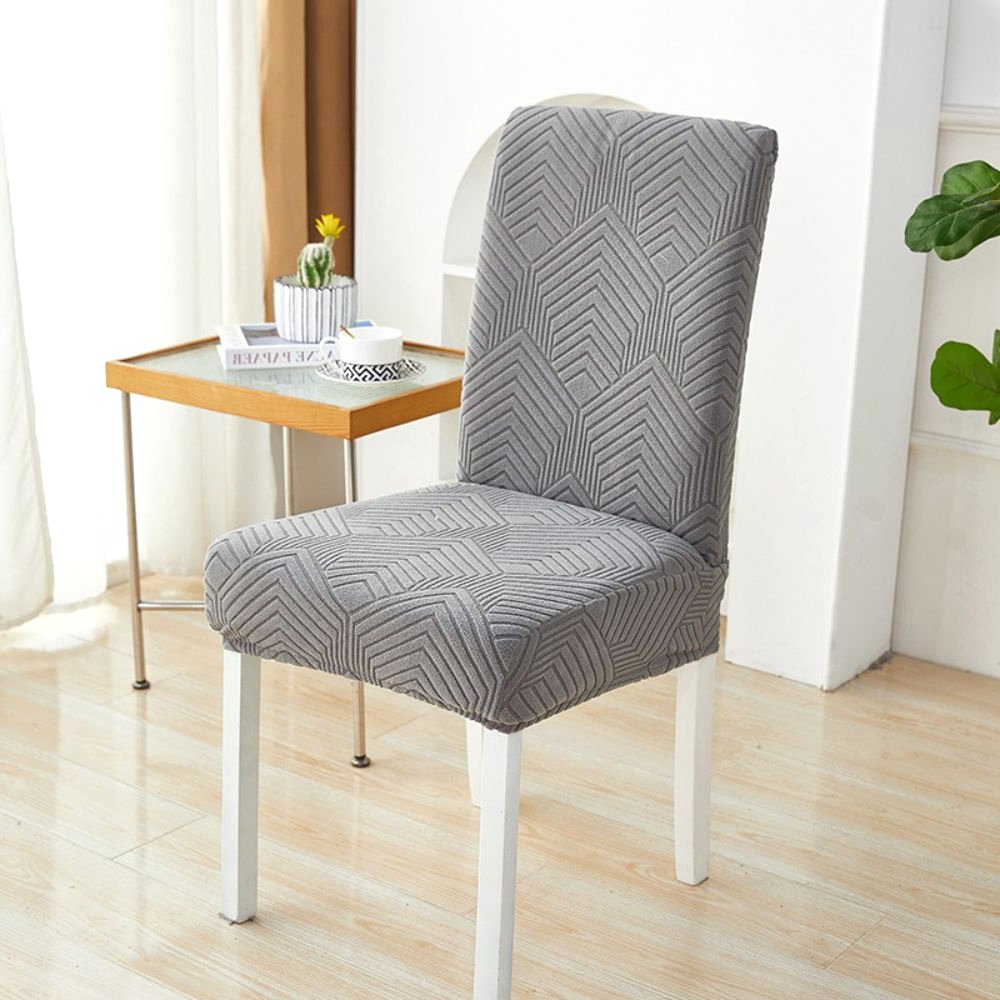 Ein anthrazitgrauer Velvet Haven Stretch-Jacquard-Stuhlbezug mit Chevron-Maze-Muster auf einem weißen Esszimmerstuhl. Der Bezug bietet eine dehnbare Passform und modernes Design, geeignet für Möbelschutz und Wohndekoration.