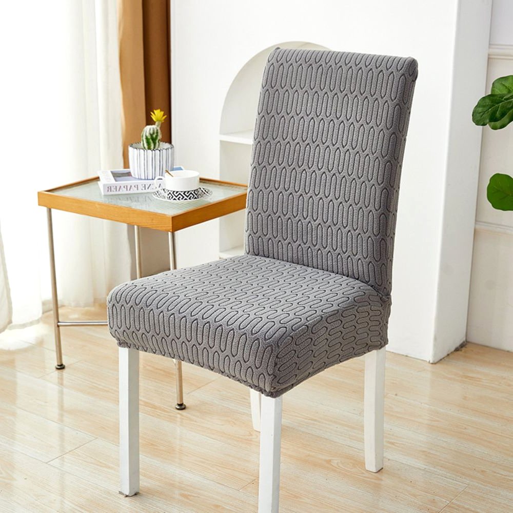 Velvet Haven Stretch-Jacquard-Stuhlbezug in Anthrazitgrau mit Ripple-Loop-Muster, das seine dehnbare Passform an einem Esszimmerstuhl zeigt. Bietet modernes Design und Möbelschutz.
